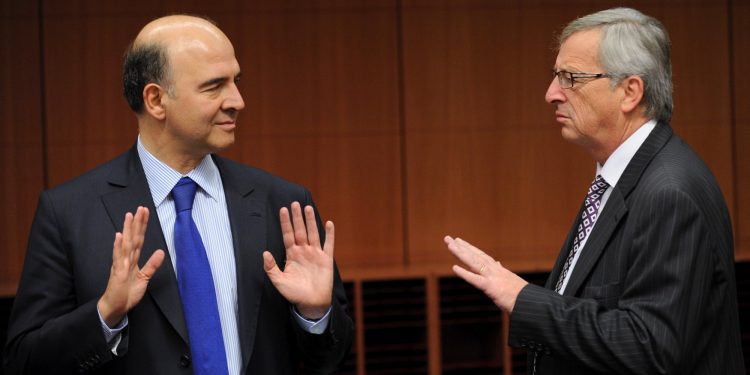 French Finance minister Pierre Moscovici (L) speaks with Luxembourg Prime Minister and Eurogroup Council president Jean-Claude Juncker (R) before an Eurozone finance ministers meeting to decide on a fresh rescue loan for debt-stricken Greece, on November 20, 2012 at EU headquarters in Brussels. Greece has "delivered" on reform and a deal will likely be clinched to unblock funds to keep it from bankruptcy, the head of the Eurogroup insisted despite a split with the IMF over how to get the stricken country's economic recovery on track.       AFP PHOTO / JOHN THYS