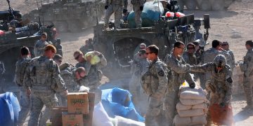 U.S. Soldiers with Charlie Company, 1st Battalion, 17th Regiment unload Humanitarian aid for distribution to the town of Rajan Kala, Afghanistan Dec. 05, 2009. Charlie Company used their Stryker armored vehicles to move the Humanitarian aid from the Joint District Community Center to the town of Rajan Kala. (U.S. Air Force photo by Tech. Sgt. Francisco V. Govea II/Released)