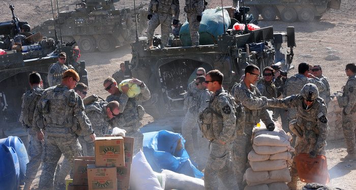 U.S. Soldiers with Charlie Company, 1st Battalion, 17th Regiment unload Humanitarian aid for distribution to the town of Rajan Kala, Afghanistan Dec. 05, 2009. Charlie Company used their Stryker armored vehicles to move the Humanitarian aid from the Joint District Community Center to the town of Rajan Kala. (U.S. Air Force photo by Tech. Sgt. Francisco V. Govea II/Released)