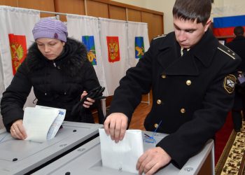 A Russian navy officer and a woman cast their ballots during the parliamentary election in Vladivostok on December 4, 2011. Russians in the Far East began voting in key parliamentary polls expected to hand victory to Vladimir Putin's party amid claims of campaign fraud and unprecedented intimidation of observers. AFP PHOTO / GENNADY SHISHKIN