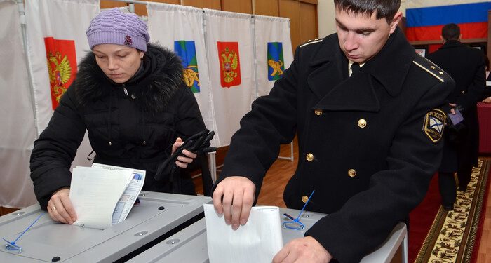 A Russian navy officer and a woman cast their ballots during the parliamentary election in Vladivostok on December 4, 2011. Russians in the Far East began voting in key parliamentary polls expected to hand victory to Vladimir Putin's party amid claims of campaign fraud and unprecedented intimidation of observers. AFP PHOTO / GENNADY SHISHKIN