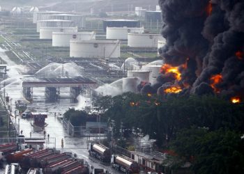 Firefighters try to extinguish a fire at a oil refinery in Puerto La Cruz August 11, 2013. Lightning set fire to a storage tank at Venezuela's Puerto La Cruz oil refinery on Sunday, the president said, and residents were moved out of the immediate area while local media showed images of thick black smoke rising from the facility. Thunderstorms this weekend have drenched much of the South American OPEC nation, which has suffered repeated accidents at its oil refineries in recent years. Lightning bolts ignited two storage tanks at a different refinery just last year. REUTERS/Stringer (VENEZUELA - Tags: DISASTER BUSINESS COMMODITIES TPX IMAGES OF THE DAY)