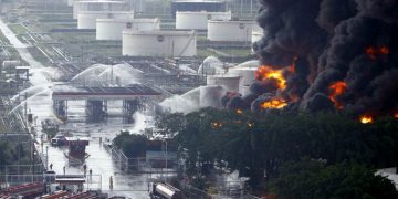 Firefighters try to extinguish a fire at a oil refinery in Puerto La Cruz August 11, 2013. Lightning set fire to a storage tank at Venezuela's Puerto La Cruz oil refinery on Sunday, the president said, and residents were moved out of the immediate area while local media showed images of thick black smoke rising from the facility. Thunderstorms this weekend have drenched much of the South American OPEC nation, which has suffered repeated accidents at its oil refineries in recent years. Lightning bolts ignited two storage tanks at a different refinery just last year. REUTERS/Stringer (VENEZUELA - Tags: DISASTER BUSINESS COMMODITIES TPX IMAGES OF THE DAY)