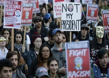 People hold signs as they listen to speakers at a protest against the election of President-elect Donald Trump, Wednesday, Nov. 9, 2016, in downtown Seattle. (AP Photo/Ted S. Warren)