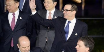 US Secretary of the Treasury Steven Mnuchin (R) waves as he and other participants in the G20 Finance Ministers and Central Bank Governors Meeting pose for the Family photo in Baden-Baden, southern Germany, on March 17, 2017.       
Finance ministers from the world's top nations gather in Germany on March 17, as fears grow of a looming trade war over US President Donald Trump's America First policy. / AFP PHOTO / Thomas Kienzle