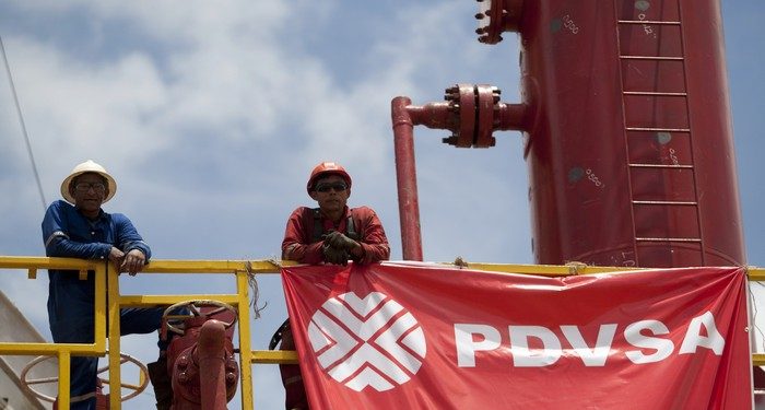 Workers stand in front of a drilling rig at an oil well operated by Venezuela's state oil company PDVSA in Morichal July 28, 2011.  Venezuela received an enviable honor last month: OPEC said it is sitting on the biggest reserves of crude oil in the world -- even more than Saudi Arabia.  But the Venezuelan oil industry is also sitting atop a well of trouble.  Picture taken July 28, 2011.  To match Special Report VENEZUELA/PDVSA  REUTERS/Carlos Garcia Rawlins (VENEZUELA - Tags: ENERGY POLITICS BUSINESS)