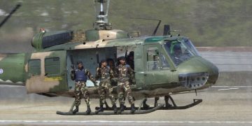 A Thai UH-1 Huey helicopter flies a Thai special operations unit in support of a pilot extraction exercise at the Royal Thai Air Force air show at Korat Air Base, Thailand, during Exercise COPE TIGER 2002.