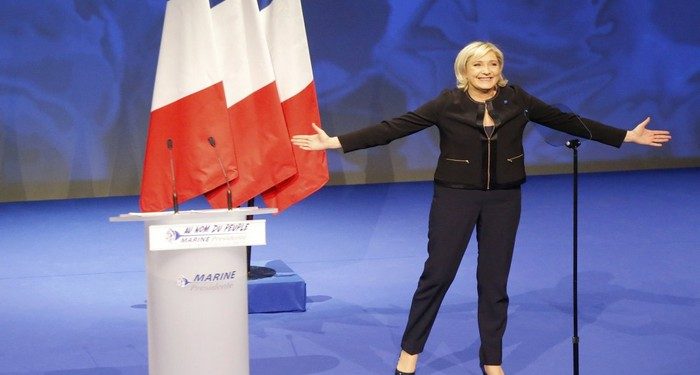 Far-right leader presidential candidate Marine Le Pen acknowledges applauses as she arrives as to a conference in Lyon, France, Sunday, Feb. 5, 2017. Marine Le Pen, the far-right presidential candidate, unveiled her platform Saturday at the start of a weekend conference, envisioning a thriving nation "made in France. (AP Photo/Michel Euler)