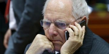 German Finance Minister Wolfgang Schaeuble speaks on his mobile phone as he takes part in a European Union finance ministers meeting in Brussels, Belgium, February 12, 2016.  REUTERS/Yves Herman