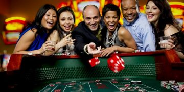 Excited friends gambling at craps table in casino