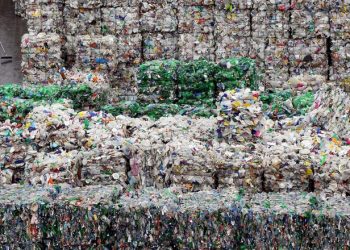 LONDON - MARCH 25:  An employee of the 'Closed Loop Recycling' plant walks past stacks of plastic bottles at their plant in Dagenham on March 25, 2010 in London, United Kingdom. The state of the art plant is the first in the UK to produce food grade recycled plastic from bottle waste. Over 35,00 tonnes of plastic bottles are recycled at the plant annually, representing almost 20% of the plastic bottles currently collected for recycling in the UK, and saving approximately 52,500 tonnes of carbon dioxide per year.  (Photo by Dan Kitwood/Getty Images)