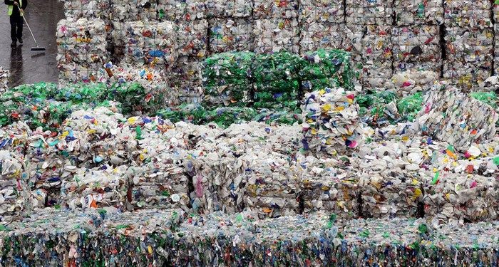 LONDON - MARCH 25:  An employee of the 'Closed Loop Recycling' plant walks past stacks of plastic bottles at their plant in Dagenham on March 25, 2010 in London, United Kingdom. The state of the art plant is the first in the UK to produce food grade recycled plastic from bottle waste. Over 35,00 tonnes of plastic bottles are recycled at the plant annually, representing almost 20% of the plastic bottles currently collected for recycling in the UK, and saving approximately 52,500 tonnes of carbon dioxide per year.  (Photo by Dan Kitwood/Getty Images)