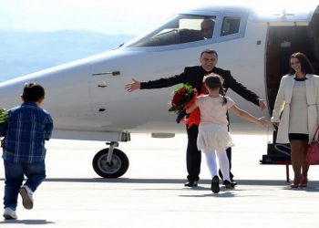 Johan Tarculovski, center, accompanied by his wife Sonja Tarculovska, right, is welcomed by his children upon his arrival at "Alexander the Great" airport near Macedonia's capital Skopje, on Thursday, April 11, 2013. Couple of thousands of people have gathered at the airport on Tuesday to welcome the return of Johan Tarculovski, the only Macedonian convicted by The Hague tribunal for war crimes committed during 2001 ethnic conflict. (AP Photo/(Boris Grdanoski)