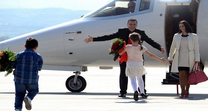 Johan Tarculovski, center, accompanied by his wife Sonja Tarculovska, right, is welcomed by his children upon his arrival at "Alexander the Great" airport near Macedonia's capital Skopje, on Thursday, April 11, 2013. Couple of thousands of people have gathered at the airport on Tuesday to welcome the return of Johan Tarculovski, the only Macedonian convicted by The Hague tribunal for war crimes committed during 2001 ethnic conflict. (AP Photo/(Boris Grdanoski)