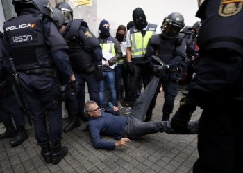 Spanish police clear the entrance of a polling station in Barcelona, on October 1, 2017, on the day of a referendum on independence for Catalonia banned by Madrid.

More than 5.3 million Catalans are called today to vote in a referendum on independence, surrounded by uncertainty over the intention of Spanish institutions to prevent this plebiscite banned by justice.
 / AFP PHOTO / PAU BARRENA