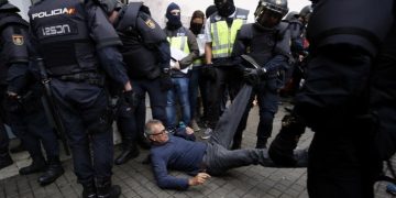 Spanish police clear the entrance of a polling station in Barcelona, on October 1, 2017, on the day of a referendum on independence for Catalonia banned by Madrid.

More than 5.3 million Catalans are called today to vote in a referendum on independence, surrounded by uncertainty over the intention of Spanish institutions to prevent this plebiscite banned by justice.
 / AFP PHOTO / PAU BARRENA