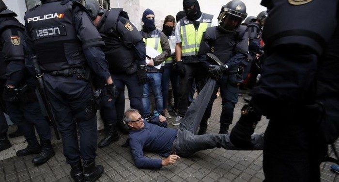 Spanish police clear the entrance of a polling station in Barcelona, on October 1, 2017, on the day of a referendum on independence for Catalonia banned by Madrid.

More than 5.3 million Catalans are called today to vote in a referendum on independence, surrounded by uncertainty over the intention of Spanish institutions to prevent this plebiscite banned by justice.
 / AFP PHOTO / PAU BARRENA