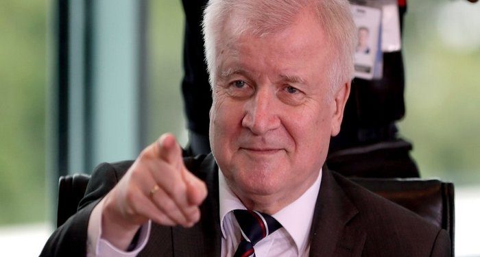 German Interior Minister Horst Seehofer points prior to the weekly cabinet meeting at the chancellery in Berlin, Germany, Friday, July 6, 2018. (AP Photo/Michael Sohn)