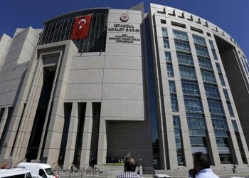 People stand outside a courthouse building in Istanbul, on Monday, Aug. 15, 2016. Police teams on Monday apprehended 136 personnel in operations conducted at three Istanbul courthouses as part of an investigation into the July 15 abortive coup. (AP Photo/Thanassis Stavrakis)