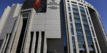 People stand outside a courthouse building in Istanbul, on Monday, Aug. 15, 2016. Police teams on Monday apprehended 136 personnel in operations conducted at three Istanbul courthouses as part of an investigation into the July 15 abortive coup. (AP Photo/Thanassis Stavrakis)