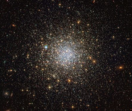 This image from the NASA/ESA Hubble Space Telescope reveals an ancient, glimmering ball of stars called NGC 1466. It is a globular cluster — a gathering of stars all held together by gravity — that is slowly moving through space on the outskirts of the Large Magellanic Cloud, one of our closest galactic neighbours. NGC 1466 certainly is one for extremes. It has a mass equivalent to roughly 140 000 Suns and an age of around 13.1 billion years, making it almost as old as the Universe itself. This fossil-like relic from the early Universe lies some 160 000 light-years away from us. Nestled within this ancient time capsule are 49 known RR Lyrae variable stars, which are indispensable tools for measuring distances in the Universe. These variable stars have well-defined luminosities, meaning that astronomers know the total amount of energy they emit. By comparing this known luminosity to how bright the stars appear in the sky, their distance can be easily calculated. Astronomical objects such as this are known as standard candles, and are fundamental to the so-called cosmic distance ladder.