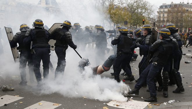 French CRS riot police apprehend a demonstrator during clashes near the Place de la Republique after the cancellation of a planned climate march following shootings in the French capital, ahead of the World Climate Change Conference 2015 (COP21), in Paris, France, November 29, 2015.     REUTERS/Eric Gaillard     - RTX1WCS1