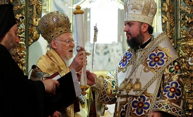 Ecumenical Patriarch Bartholomew I hands Tomos, a decree granting Ukraine church independence, to Metropolitan Epifaniy, head of the Orthodox Church of Ukraine, after the Epiphany mass at the Patriarchal Cathedral of St. George in Istanbul, Turkey January 6, 2019. REUTERS/Murad Sezer