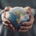 closeup of a young caucasian man with a world globe wrapped in bubble wrap in his hands