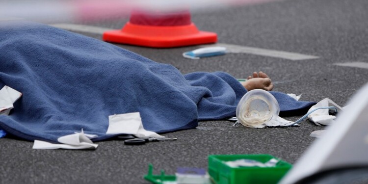 A covered body lies on the street after a car crashed into a crowd of people in central Berlin, Germany, Wednesday, May 8, 2022. (AP Photo/Michael Sohn)