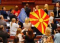 North Macedonian members of Parliament from the ruling SDSM party, hold European Union and North Macedonian flags, during a parliamentary debate on a French-brokered deal aimed at settling disputes with Bulgaria and clearing the way to EU membership, in Skopje, North Macedonia, July 16, 2022. REUTERS/Ognen Teofilovski