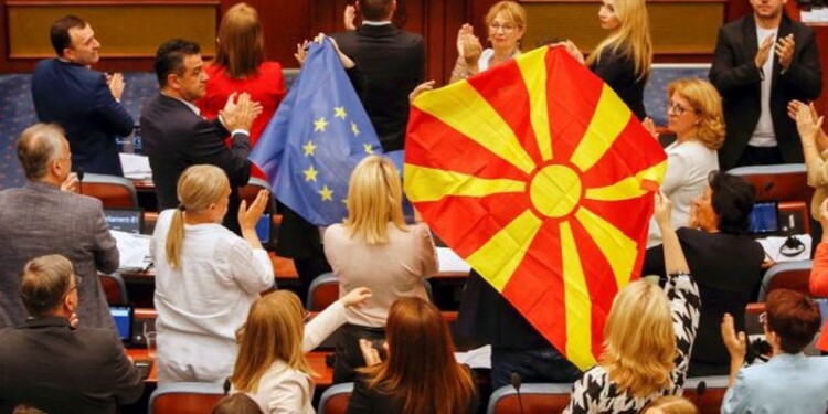 North Macedonian members of Parliament from the ruling SDSM party, hold European Union and North Macedonian flags, during a parliamentary debate on a French-brokered deal aimed at settling disputes with Bulgaria and clearing the way to EU membership, in Skopje, North Macedonia, July 16, 2022. REUTERS/Ognen Teofilovski