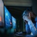 Frustrated and worried businessman with computer sitting at desk, working late. Financial crisis concept.