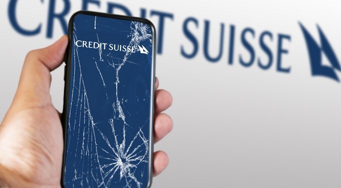 New York, US, March 2023: Hand holding a phone with the Credit Suisse logo on the cracked screen. In March 2023, Credit Suisse experienced a sharp drop in its stock price. Illustrative editorial