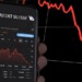 New York, US, March 2023: hand holding a phone with the performance of Credit Suisse on stock market. In March 2023, Credit Suisse experienced a sharp drop in its stock price. Illustrative editorial