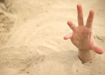 Hand sinking in quicksand, trying to get out, tips to survive in desert, buried