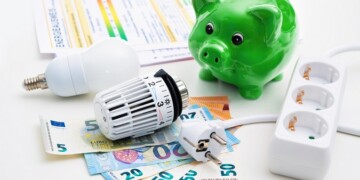 Energy cost, saving energy concept. Piggy bank with money, plug, bulb and radiator thermostat on white background