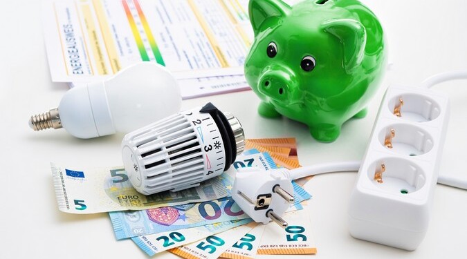 Energy cost, saving energy concept. Piggy bank with money, plug, bulb and radiator thermostat on white background