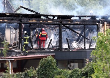 Firefighters inspect a burnt building after a fire erupted at a holiday home for disabled people in Wintzenheim, eastern France, on August 9, 2023. Authorities found nine corpses after a fire ravaged a centre housing holidaying adults with learning difficulties in eastern France, the fire brigade said. (Photo by Sebastien BOZON / AFP)