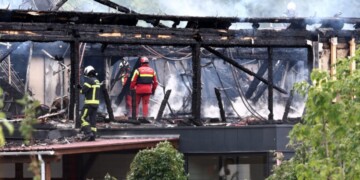 Firefighters inspect a burnt building after a fire erupted at a holiday home for disabled people in Wintzenheim, eastern France, on August 9, 2023. Authorities found nine corpses after a fire ravaged a centre housing holidaying adults with learning difficulties in eastern France, the fire brigade said. (Photo by Sebastien BOZON / AFP)