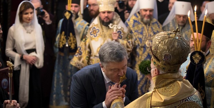 epaselect epa07264632 Ukrainian President Petro Poroshenko (C) kisses the hand of Ecumenical Patriarch Bartholomew I (R) during the handing ceremony of the Tomos decree of autocephaly for Ukrainian church at the Patriarchal Church of St. George in Istanbul, Turkey, 06 January 2019. The Metropolitan Epifaniy and top Ukrainian officials arrived in Turkey for the ceremony of the Tomos of autocephaly for newly elected the head of Ukraine Orthodox Church in Istanbul.  EPA-EFE/TOLGA BOZOGLU