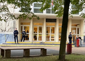 Police officers stand guard outside the high school where a man stabbed a teacher, Saturday Oct.14, 2023 in Arras, northern France. A man of Chechen origin who was under surveillance by French security services over suspected Islamic radicalization stabbed a teacher to death at his former high school and wounded three other people Friday in Arras. (AP Photo/Jeffrey Schaeffer)