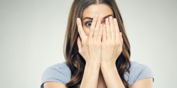 Close up face woman portrait with fear emotion. Isolated in studio.