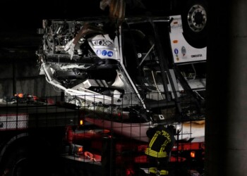 Italian firefighters work at the scene of a passenger bus accident in Mestre, near the city of Venice, Italy, Wednesday, Oct. 4, 2023. The bus fell from an elevated road, late Tuesday, killing multiple people. (AP Photo/Antonio Calanni)