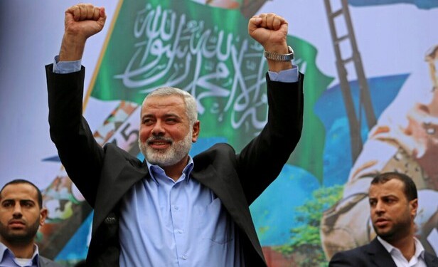 Palestinian top Hamas leader Ismail Haniyeh greets supporters during a rally to commemorate the 27th anniversary of the Hamas militant group, at the main road in Jebaliya in the northern Gaza Strip, Friday, Dec. 12, 2014. (AP Photo/Adel Hana)