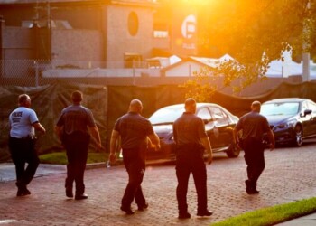 Police officers walk toward the scene of the mass shooting at the Pulse nightclub early Tuesday, June 14, 2016, in Orlando, Fla. (AP Photo/David Goldman)