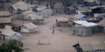 FILE - People stand by their houses in Juba, South Sudan, on Feb. 5, 2023. South Sudan’s government is closing down all schools starting Monday as the country prepares for a wave of extreme heat expected to last two weeks. The health and education ministries advised parents to keep all children indoors as temperatures are expected to soar to 113 Fahrenheit, in a statement late Saturday. (AP Photo/Gregorio Borgia, File)