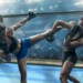 Two professional female mixed martial arts fighters competing in an octagon cage in a floodlit arena full of spectators. One fighter strikes her opponent with leg raised in a roundhouse kick. Her opponent blocks the blow with her arm. Both fighters are wearing shorts/bra tops and protective gloves.