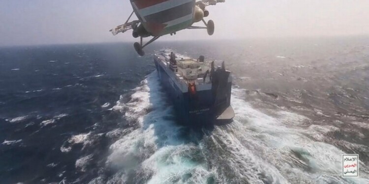 This photo released by the Houthi Media Center shows a Houthi forces helicopter approaching the cargo ship Galaxy Leader on Sunday, Nov. 19, 2023. Yemen's Houthis have seized the ship in the Red Sea off the coast of Yemen after threatening to seize all vessels owned by Israeli companies. (Houthi Media Center via AP)