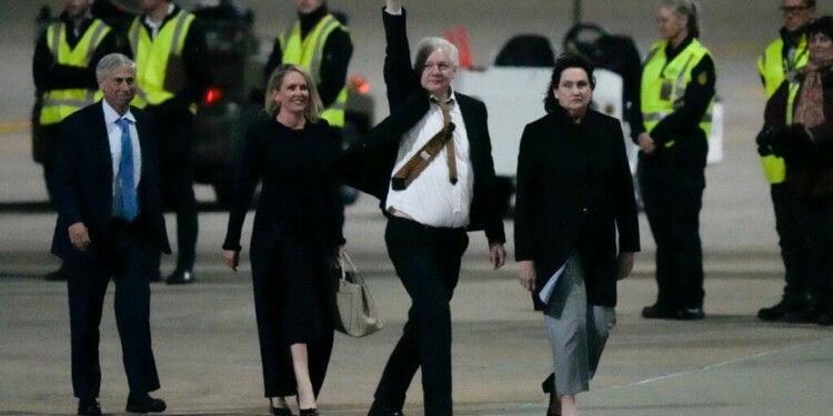 WikiLeaks founder Julian Assange gestures after landing at RAAF air base Fairbairn in Canberra, Australia, Wednesday, June 26 2024. Assange has returned to his homeland Australia aboard a charter jet hours after pleading guilty to obtaining and publishing U.S. military secrets in a deal with Justice Department prosecutors that concludes a drawn-out legal saga.(AP Photo/Rick Rycroft)