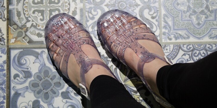 Transparent plastic shoe on female feet